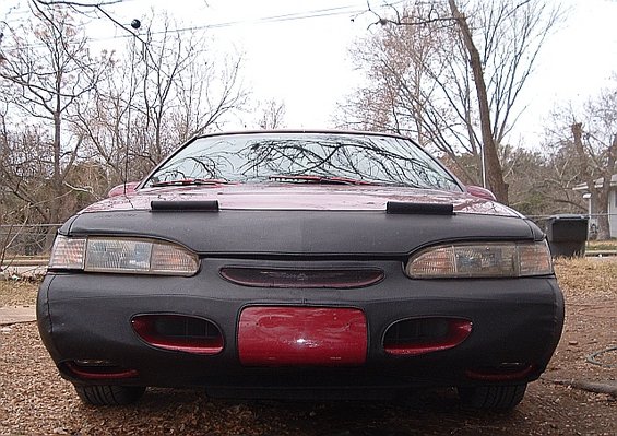 Front view of a red 1994 Ford Thunderbird with a black car bra