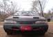 1994 Ford Thunderbird - The front of a red 1994 Ford Thunderbird is shown, partially covered by a black car bra.
