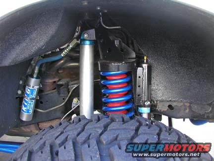 Close-up of a vehicle's front suspension with King shocks and a blue coilover spring