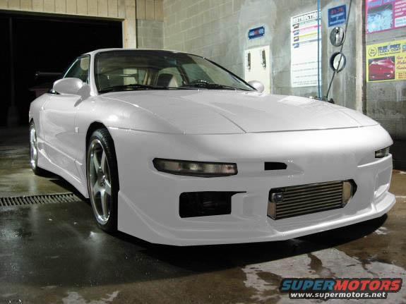 White 1994 Ford Probe with aftermarket body kit and intercooler, parked inside a car wash