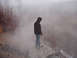 1979 Ford Bronco - A person surveys a misty, desolate environment from a rocky outcrop.