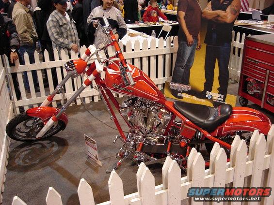 Red custom chopper motorcycle with white striped handlebars and orange flame paint