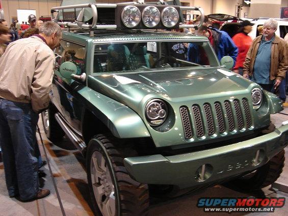 Green Jeep concept SUV with roof rack and spotlights, people looking at it