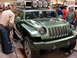 2000 Ford Crown Victoria - A green Jeep concept vehicle is on display indoors, with several people observing it.