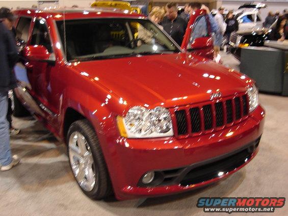 Red Jeep Grand Cherokee parked indoors, front grille and headlights visible