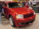 2000 Ford Crown Victoria - Red Jeep Grand Cherokee on display at an auto show, showing its distinctive grille.