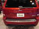 2000 Ford Crown Victoria - The rear of a red Jeep Grand Cherokee SRT8 is shown, chrome accents and dual exhaust pipes.