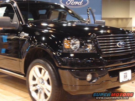 Black 2004 Ford F-150 truck, front passenger side, grille, headlights, open door, Ford logo backdrop