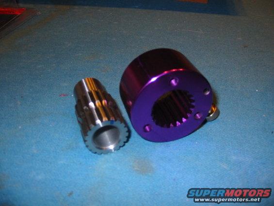 Two metal automotive parts, one silver and splined, the other purple with bolt holes