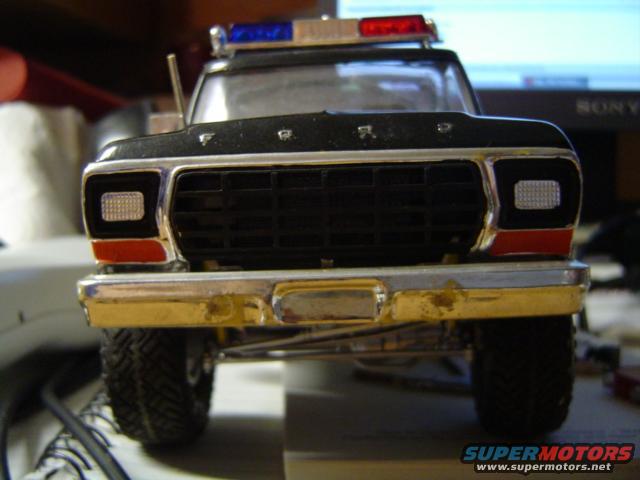 Front view of a model police truck with a light bar on top. It has a black grille and chrome bumper