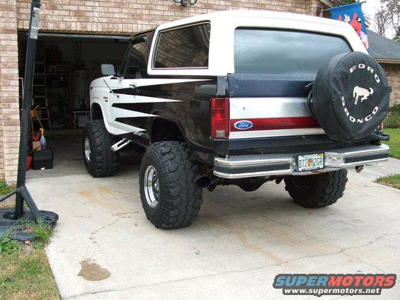 Lifted Ford Bronco with black and white graphics, spare tire on rear