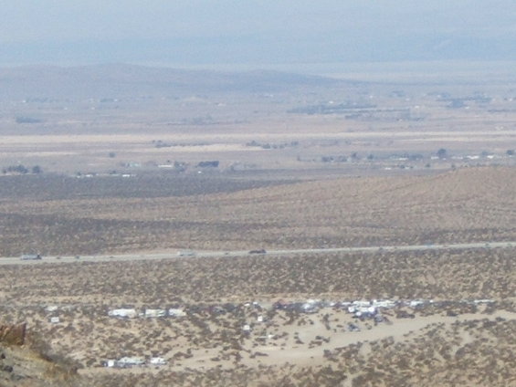 Desert scene with highway and scattered vehicles