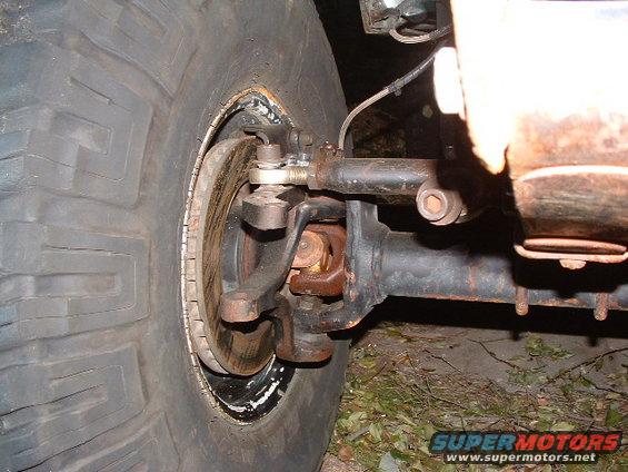 Front wheel and suspension assembly with large tire and visible brake rotor