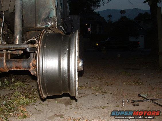 Close-up of a Jeep YJ wheel and axle assembly, with part of the vehicle body visible