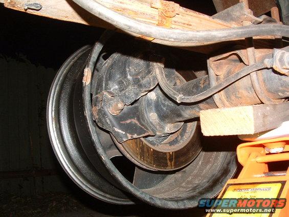 close-up of vehicle's rear axle, brake drum, and leaf spring assembly