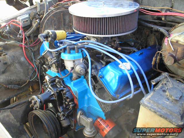 Engine bay with blue valve covers, large air filter, and visible wiring