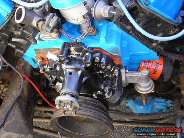 Close-up of engine parts including a blue painted block, black oil pump, and orange Fram oil filter