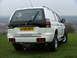 2006 Mitsubishi L200 - Rear view of a white Mitsubishi Pajero Sport SUV with a tow hitch, parked outdoors on a grassy hill.