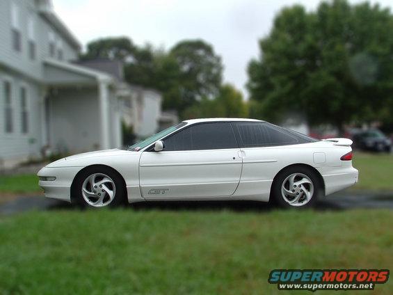 White 1996 Ford Probe GT coupe parked on grass next to a house