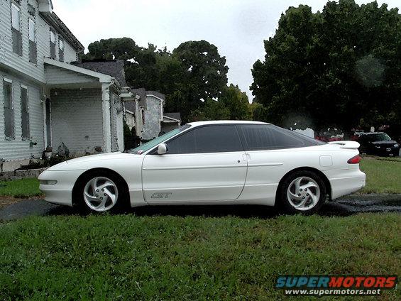 White 1996 Ford Probe GT parked by a house, with another car in the background