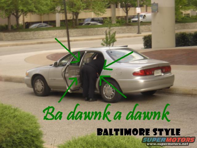 Silver sedan with rear doors open, person in black clothing bending into the driver's side