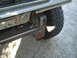 1984 Ford Bronco - Close-up view of a custom front bumper and a off-road tire on a vehicle.