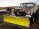 1979 Ford Bronco - A 1978 Ford Bronco equipped with a front plow sits in a muddy field, with another truck visible in the background.