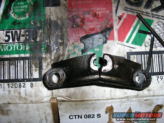 Broken metal engine part on top of oil packaging. Hex wrench visible