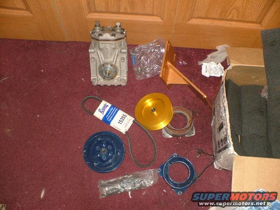 Air conditioning compressor, belt, and mounting bracket