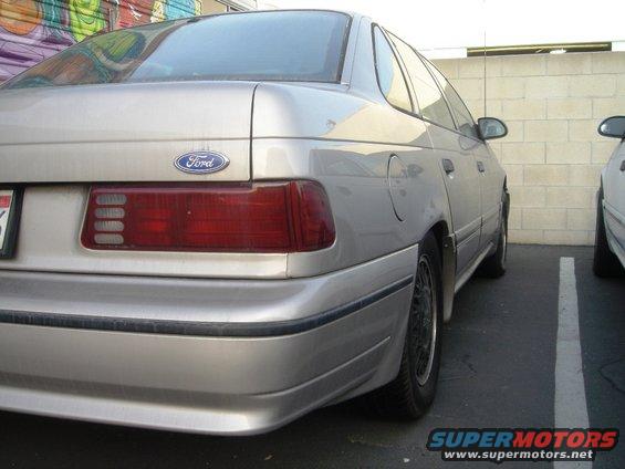 Rear of a silver Ford Taurus parked next to another car