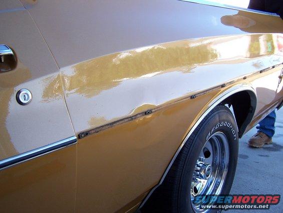 100_0389.jpg First shot of dent with trim removed.  75% of dent already hammered out at this point.