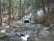 1978 Ford Bronco - A 1978 Ford Bronco navigates a challenging off-road trail with rocky terrain and scattered snow.