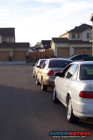 White 1998 Mercury Sable parked on asphalt, side view, with other cars behind it