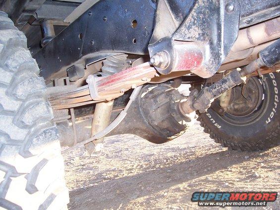 Close-up of a vehicle's rear axle, leaf springs, and driveshaft