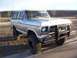 1978 Ford Bronco - Silver 1978 Ford Bronco with a custom bull bar and off-road tires sits parked on a sunny day.