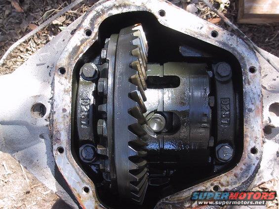 Differential housing with gears and bolts, showing internal components