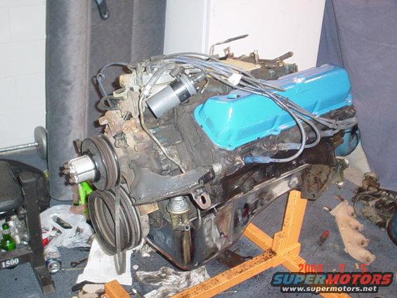 V8 engine with blue valve covers on an orange engine stand, showing pulleys and distributor