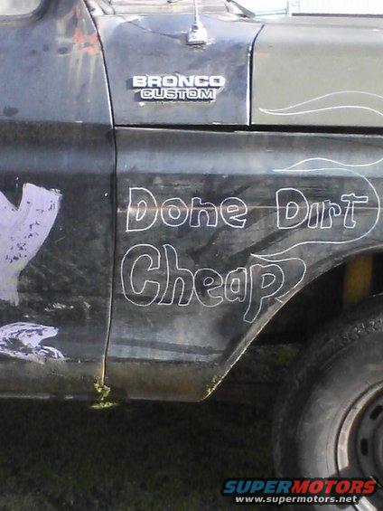 Side view of a 1978 Ford Bronco Custom with 'Done Dirt Cheap' lettering