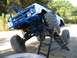1971 Ford Bronco - This heavily modified vehicle is positioned on a ramp, its off-road capabilities and custom blue roll cage.