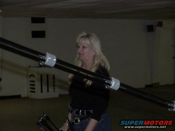 Woman holding archery equipment in an indoor space
