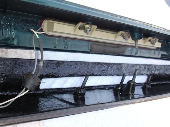 Inside of a car trunk, showing wiring and mounting hardware for a light