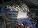 1986 Ford Bronco - Close-up view of an engine bay prominent blue hoses and an aftermarket intake component.