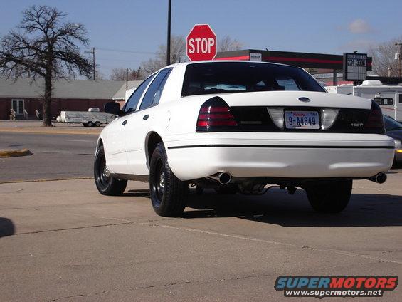 Rear view of a white 2000 Ford Crown Victoria with blacked-out taillights and a license plate reading 9-A4649