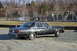 1991 Ford Crown Victoria - A black sedan is parked on a gravel lot with a playground in the background.