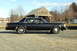 1991 Ford Crown Victoria - Side view of a black sedan parked outdoors on a gravel surface.