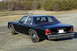 1991 Ford Crown Victoria - A black 1991 Ford Crown Victoria is parked on a gravel lot with trees in the background.