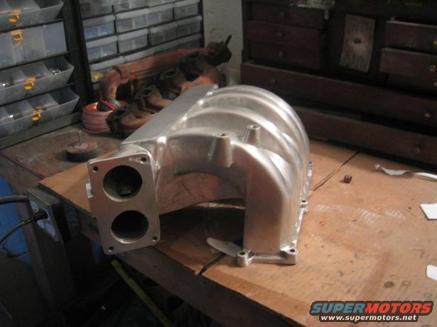 Aluminum intake manifold with dual throttle body openings on a workbench