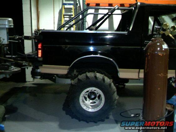 1989 Ford Bronco side view, showing roll cage and oversized mud tires