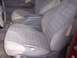1995 Toyota Tacoma - The interior of this red truck shows significant wear on the fabric seats and center console.