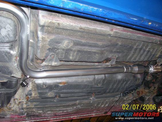 Underside of a blue vehicle showing a new exhaust pipe and fuel tank. Date stamp reads 02/07/2006